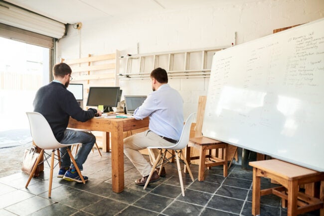 Deux hommes travaillant dans un bureau à domicile/garage aménagé