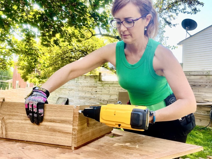 Une personne utilisant l'agrafeuse DeWalt Crown pour fixer un morceau de bois lors d'un test pratique.