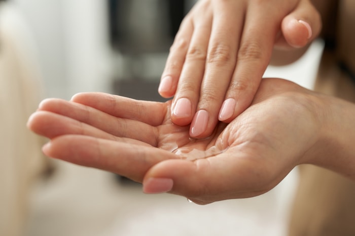 Les mains d'une femme'frottant des huiles essentielles dans ses paumes