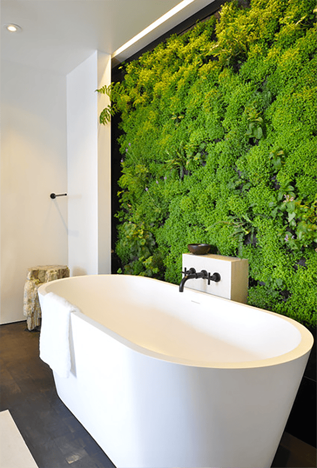 jardin vertical à l'intérieur d'une salle de bain à côté d'une grande baignoire