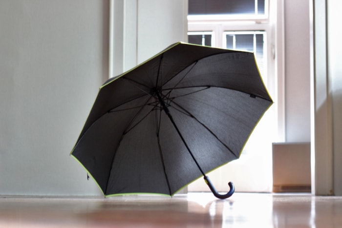 Parapluie noir ouvert à la maison