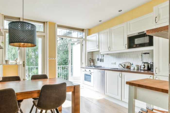 Une cuisine et une salle à manger lumineuses et chaleureuses avec une peinture d'accent jaune.