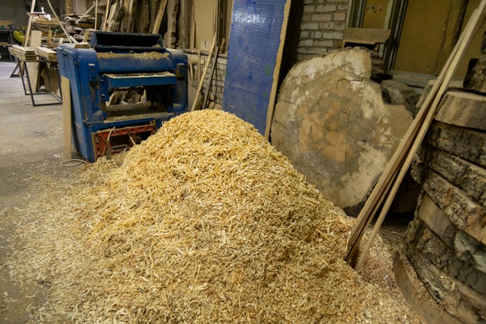 Tas de sciure près d'une machine à bois dans un atelier