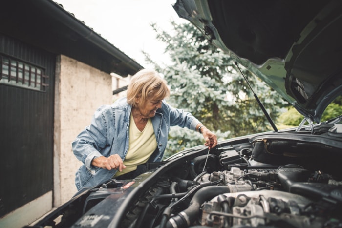 entretien-de-la-voiture-au-printemps-une-femme-agee-verifie-l-huile-moteur-dans-la-voiture