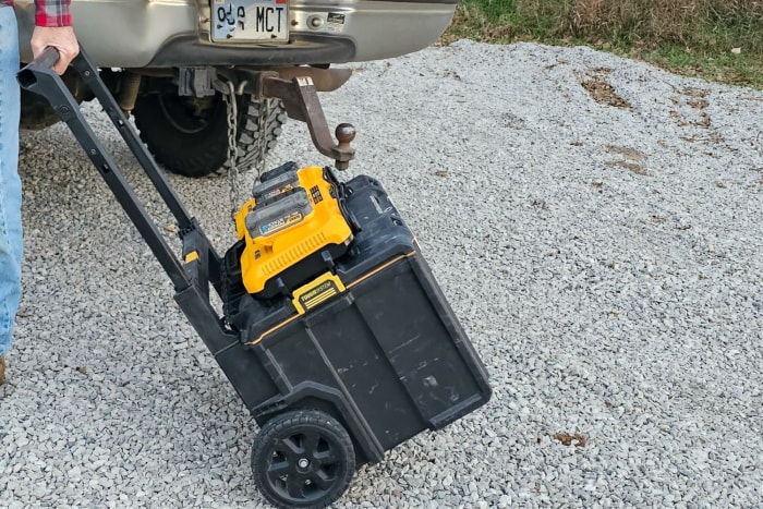 La station de charge Dewalt sur le dessus d'une boîte à outils roulante pendant qu'elle est transportée vers un chantier.