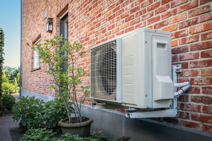 Pompe à chaleur et système énergétique perchés à l'extérieur d'une maison en brique