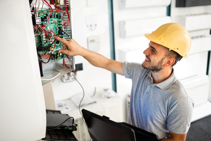 Électricien pointant le panneau électrique.