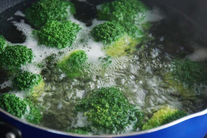 vue rapprochée du brocoli en train de bouillir dans une grande casserole d'eau chaude