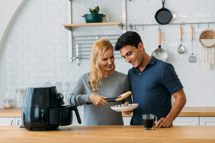 couple dans la cuisine utilisant une friteuse