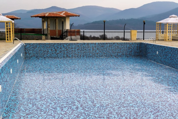 Une vue d'une piscine creusée avec un arrière-plan de montagne.