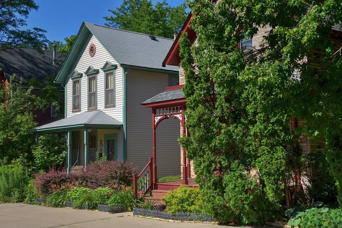 Une maison blanche historique dans le quartier historique de Milwaukee Avenue, entourée de verdure