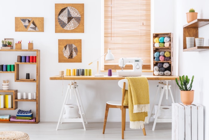 intérieur de chambre coloré avec un bureau, une machine à coudre et du fil