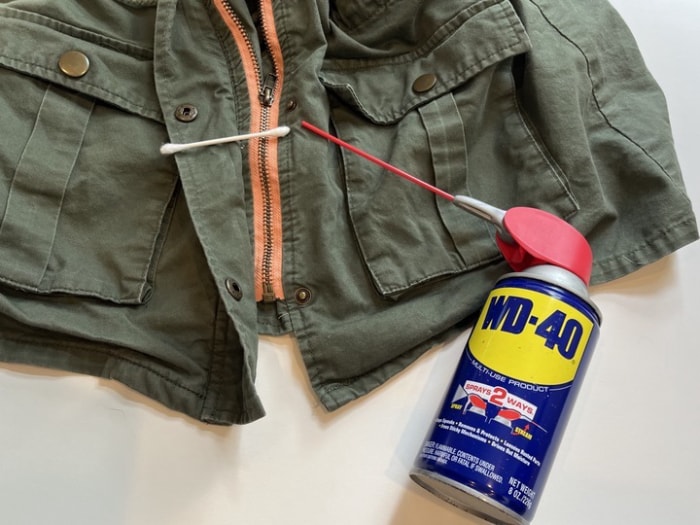 Utiliser du WD40 et un coton-tige sur la fermeture éclair coincée d'une veste.