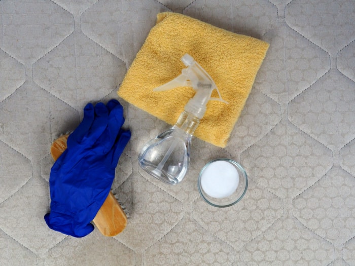 vue d'ensemble du matelas avec une tasse de bicarbonate de soude et d'autres produits de nettoyage