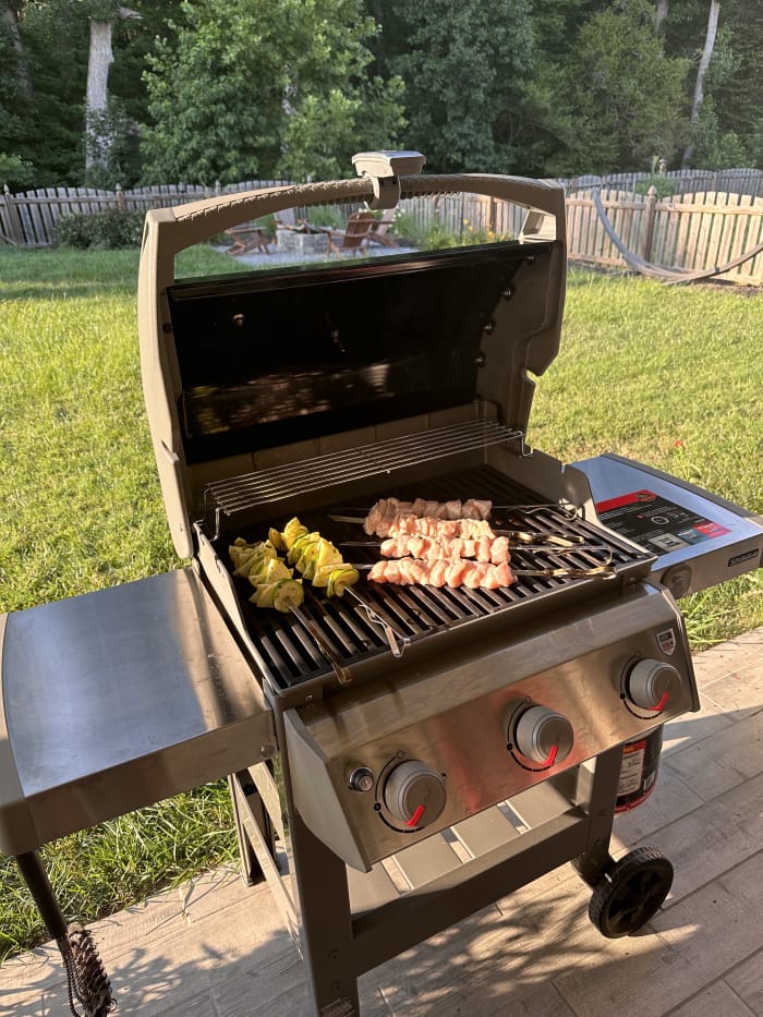 Aliments déposés sur les grilles en fonte du barbecue Weber E-310