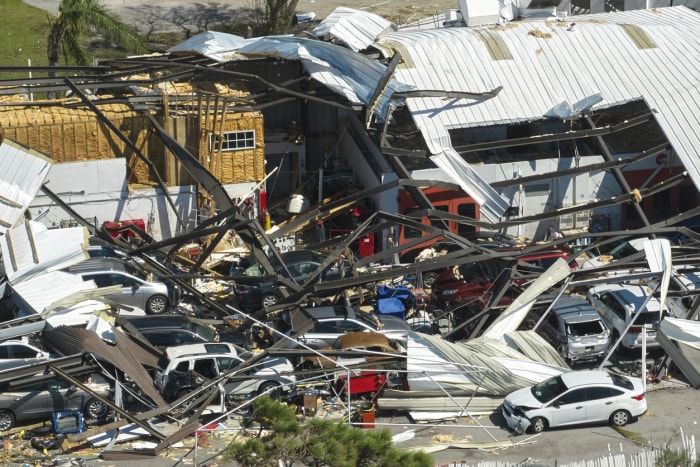 L'ouragan Ian a détruit un bâtiment industriel avec des voitures endommagées sous les ruines en Floride. Catastrophe naturelle et ses conséquences.