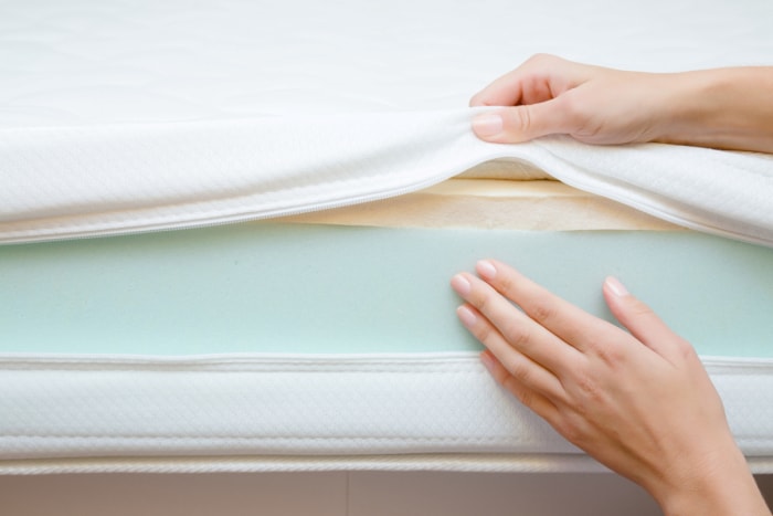 Personne touchant différentes couches de matelas en mousse