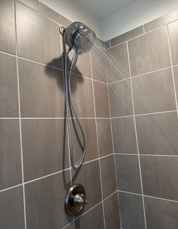 Pommeau de douche chromé American Standard Spectra Plus Duo monté sur un mur en carrelage taupe carré