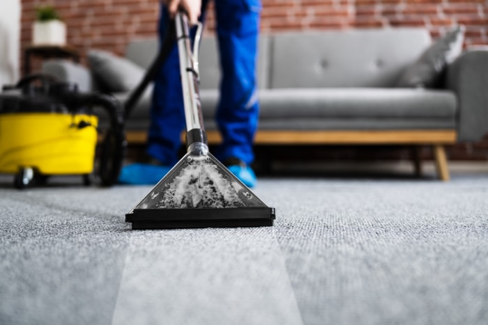 iStock-1291113951 Remboursement d'impôt Améliorations domiciliaires Nettoyage de tapis par un concierge avec un aspirateur