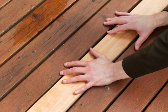 Personne plaçant ses mains sur une nouvelle planche de pont