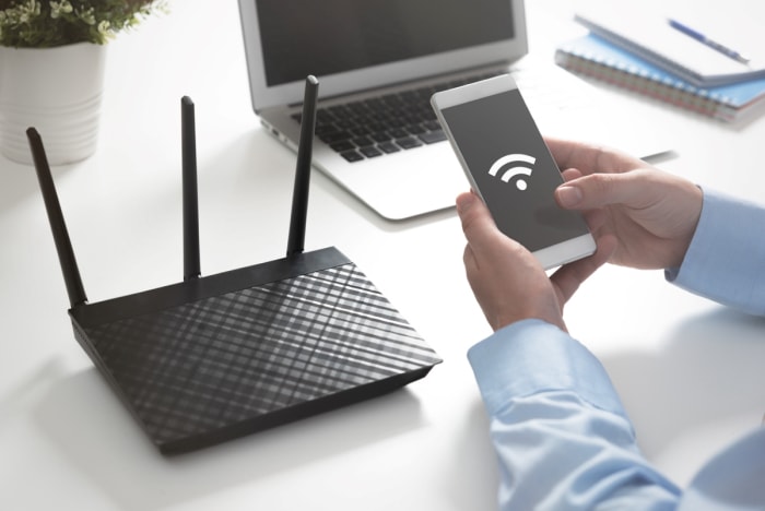 Personne cherchant à connecter son téléphone à un routeur Wi-Fi