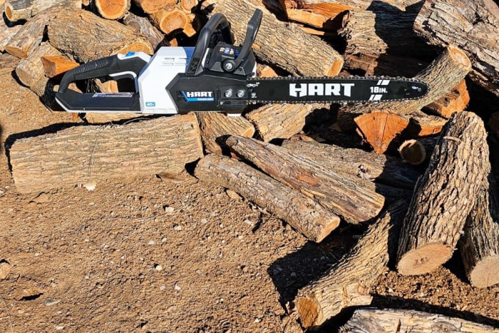 La tronçonneuse Hart 40V sur une pile de bûches coupées pendant les tests.