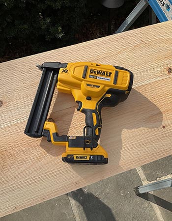 L'agrafeuse DeWalt Crown sur un morceau de bois lors d'un test pratique.