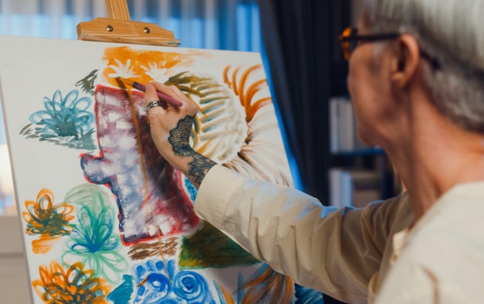 Femme âgée faisant de l'art sur toile.