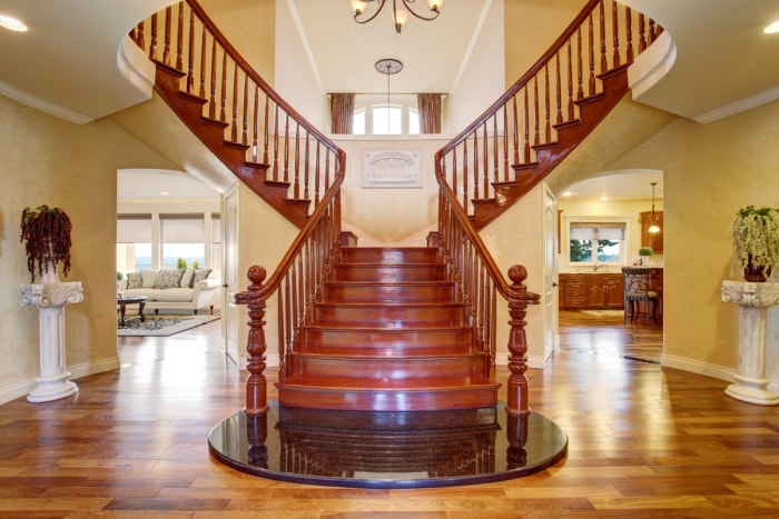 Grand escalier en bois bifurqué menant de part et d'autre du deuxième étage d'une maison traditionnelle.