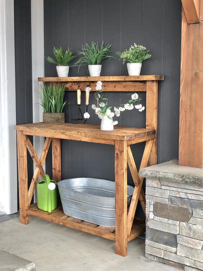 Banc de rempotage de style ferme avec plantes en pot sur l'étagère supérieure