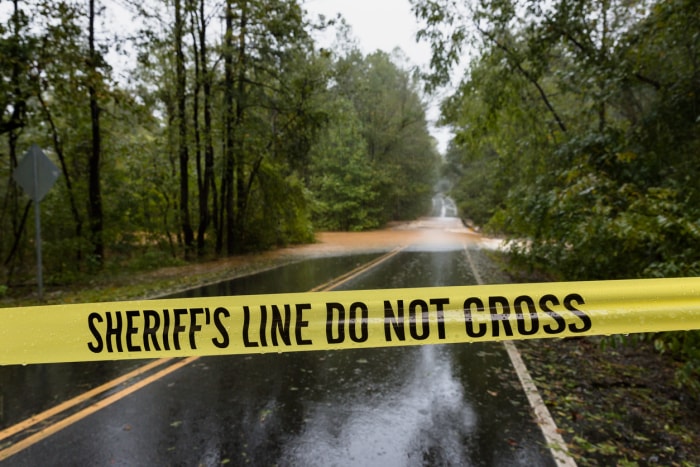 Un cordon de police délimite une route inondée