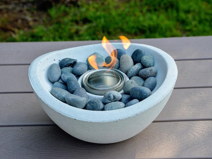 Le bol à feu de table TerraFlame Wave sur une table de pique-nique extérieure pendant les tests.