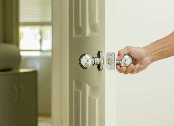 porte fermant à la main dans la maison