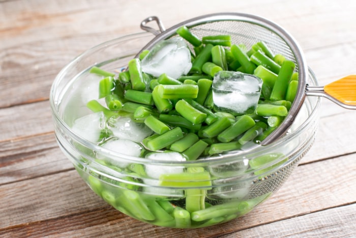 Blanchir les haricots verts cuits dans de l'eau froide