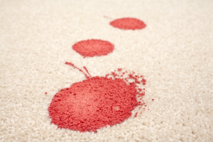 taches de peinture rouge sur un tapis blanc