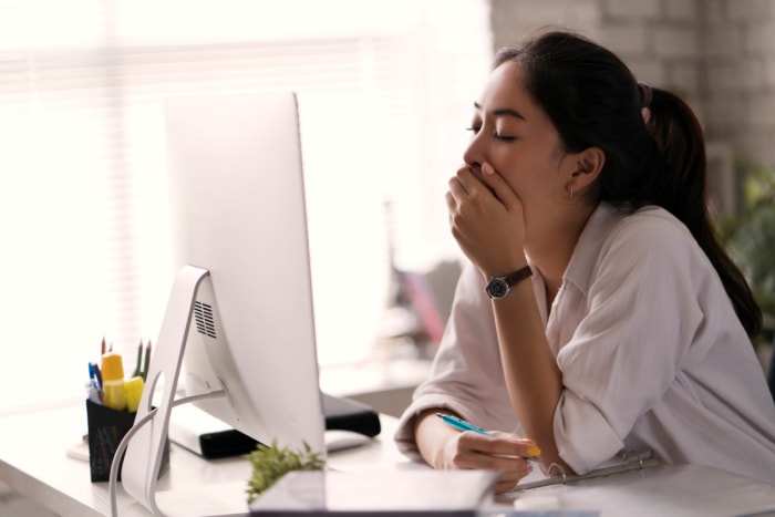 heure d'été 2023 - femme bâillant devant l'ordinateur