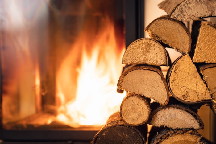 Pile de bois de chauffage devant la cheminée.