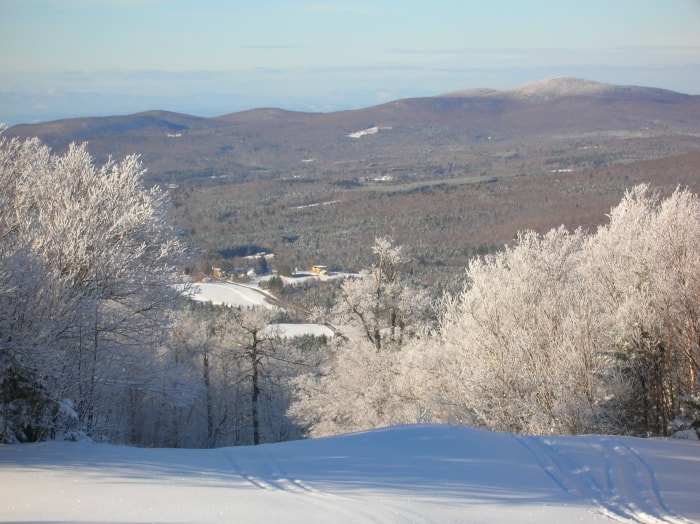 vue d'un paysage de collines et d'une ville enneigée