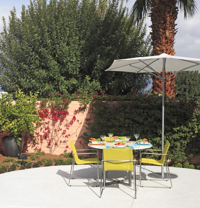 table de salle à manger d'extérieur dans le patio avec parapluie blanc