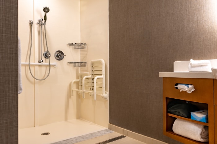 Salle de bain et douche accessibles aux fauteuils roulants avec protections.