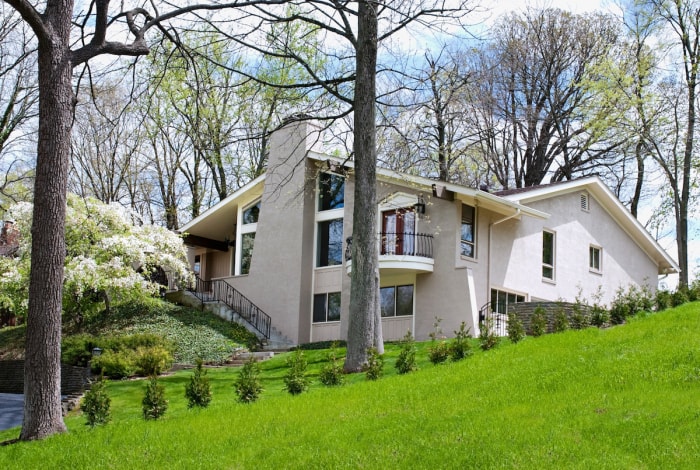 maison en stuc blanc avec une pelouse en pente