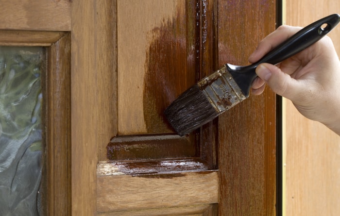 pinceau pour sceller le bois sur une porte en bois