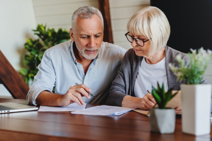 iStock-1264328258 communauté planifiée Couple mûr avec documents financiers à l'intérieur de la maison