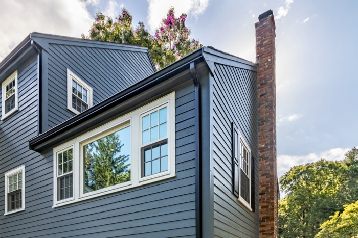 maison avec revêtement en panneaux Hardie bleu foncé et garniture blanche