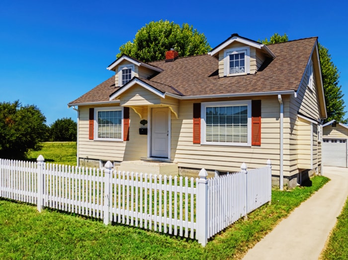 petite maison avec une clôture partielle dans la cour avant