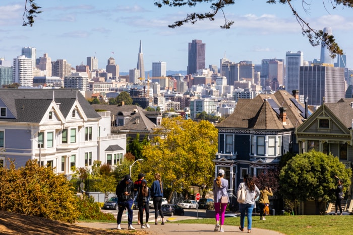 San Francisco, Californie, États-Unis - 29 septembre 2019 : Des gens profitent d'activités de plein air et d'une vue sur les maisons Painted Ladies à Alamo Square avec en arrière-plan la ville en automne.