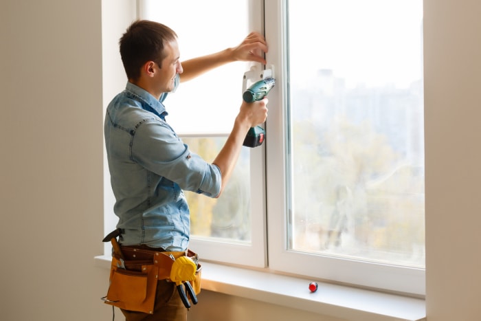 iStock-1186963326 rabais et crédits d'impôt homme installant une fenêtre.jpg