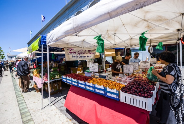 Marché fermier dans le port de San Francisco, les gens achètent des fruits biologiques frais.