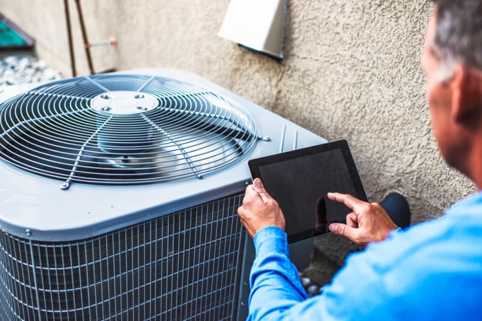 Personne utilisant une tablette pour vérifier le système de chauffage, de ventilation et de climatisation