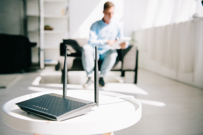 modem vs routeur routeur sur table dans un bureau à domicile homme travaillant en arrière-plan